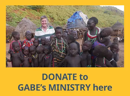 Maryknoller Gabe in front of a Kenyan village surrounded by 18 of the village children, mostly shirtless, and an elder woman, with text inviting donations to his ministry.