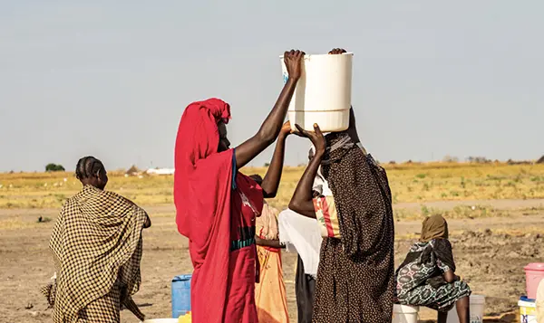 Girls carrying water buckets