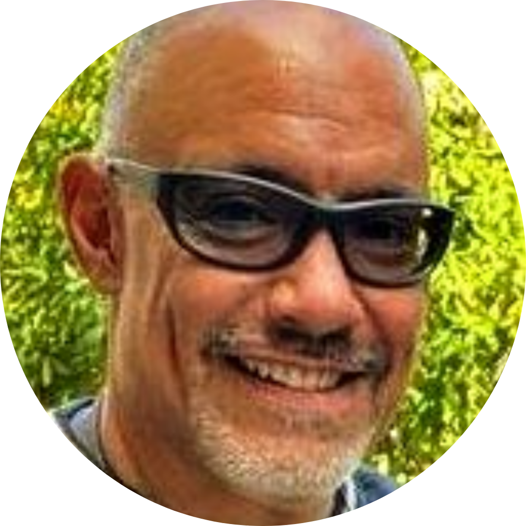 Maryknoll Lay Missioner, Gaby Hernandez, stands in front of the American, Bolivia, Vatican, and El Salvador flags signifying her connection to MKLM in America, her home nation of El Salvador, the Catholic connection from the Vatican, and her place of mission in Bolivia.